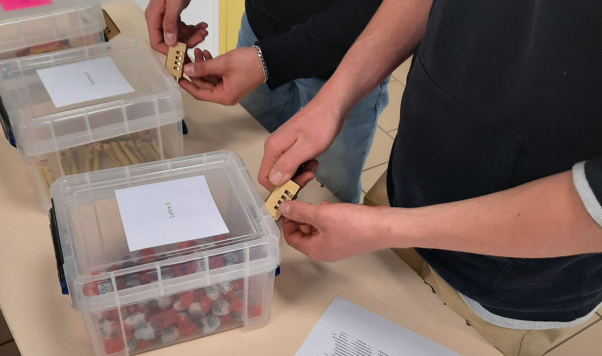 Students trying to open a treasure chest after solving cryptography puzzles.