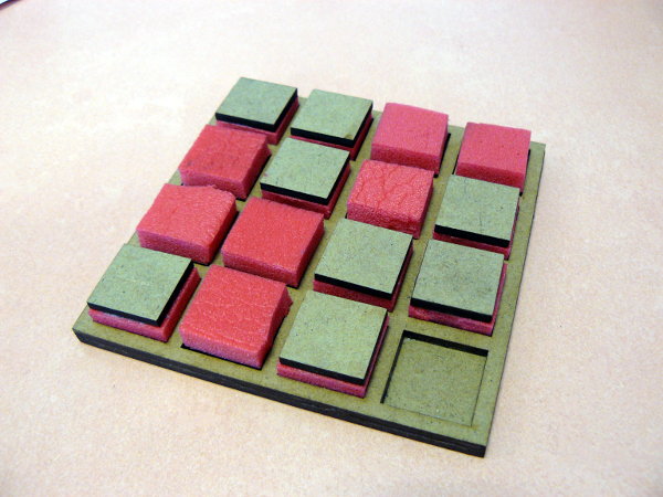Un plateau de 4x4 avec des pions à deux faces au toucher distinct